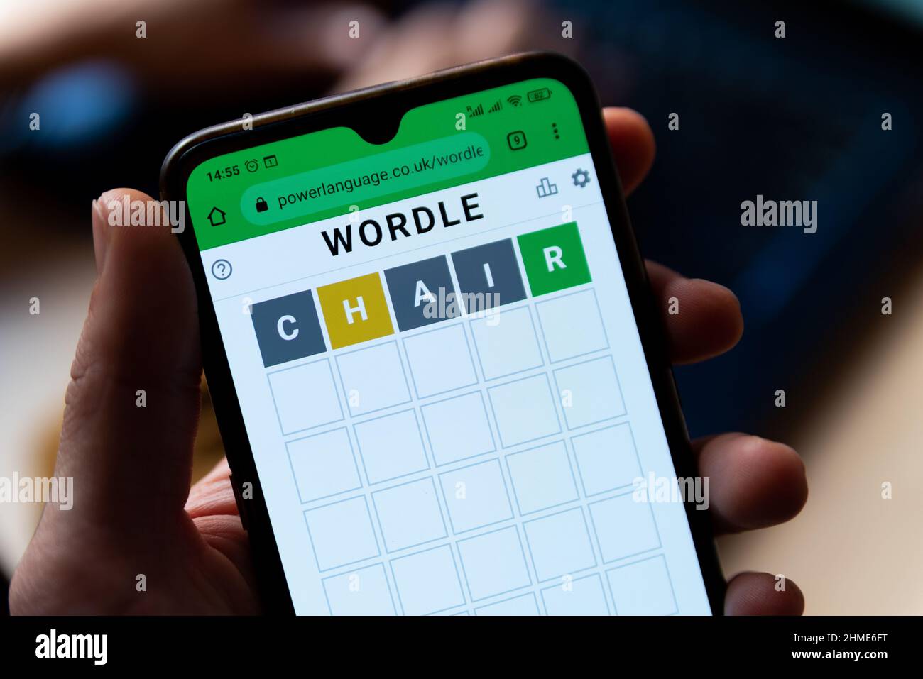 Ein Mann spielt mit dem Wortspiel Wordle aus der Nähe auf einem Handybildschirm auf der offiziellen App-Website in Barcelona, Spanien - 9. Februar 2022. Stockfoto