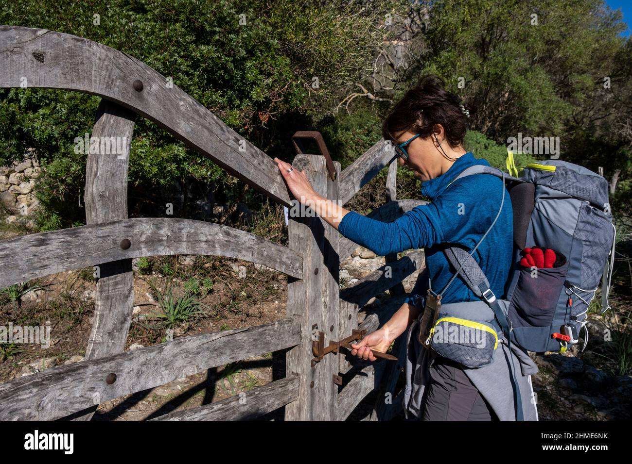 Frau, die eine typische mallorquinische Bergbarriere öffnet, Assarell, Pollença, Mallorca, Balearen, Spanien Stockfoto