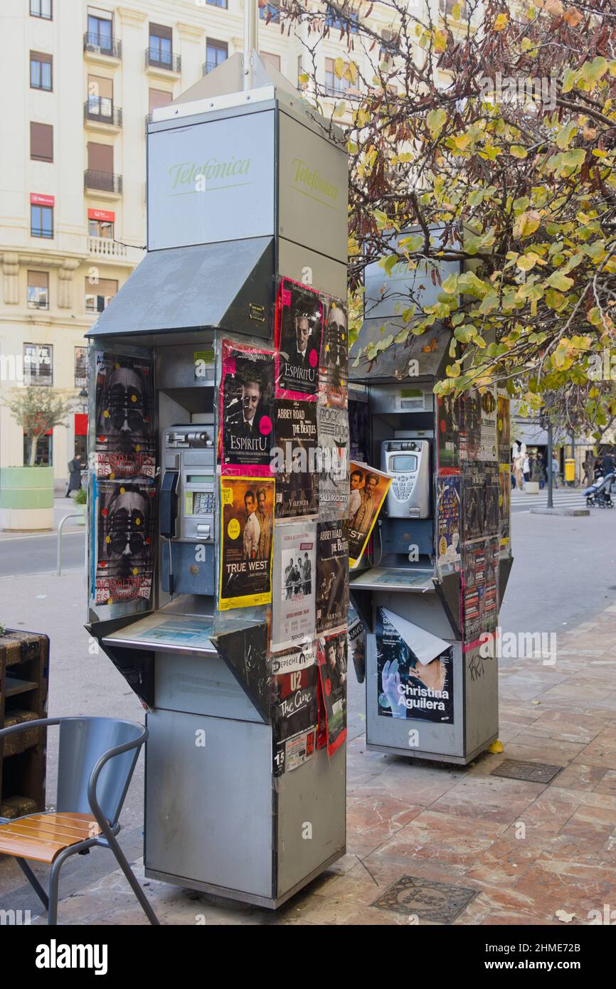 Februar 2022. Valencia, Spanien. Blick auf zwei Telefonzellen auf den Gehwegen der Plaza del Ayuntamiento in Valencia mit Ankündigungen von Stockfoto