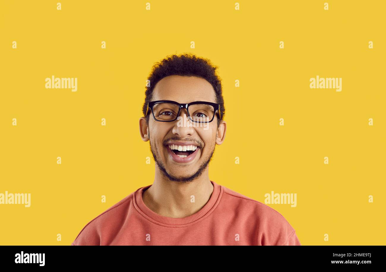 Headshot eines fröhlichen, fröhlichen schwarzen Studenten, der lächelnd und lachend die Kamera ansah Stockfoto