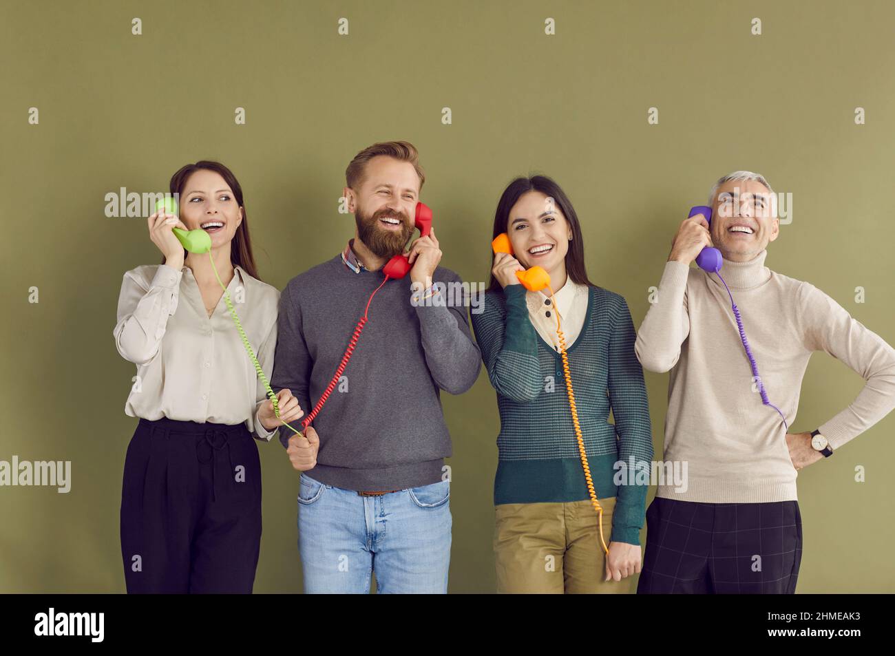 Lächelnde Menschen sprechen über das Festnetztelefon mit dem Kundenservice Stockfoto