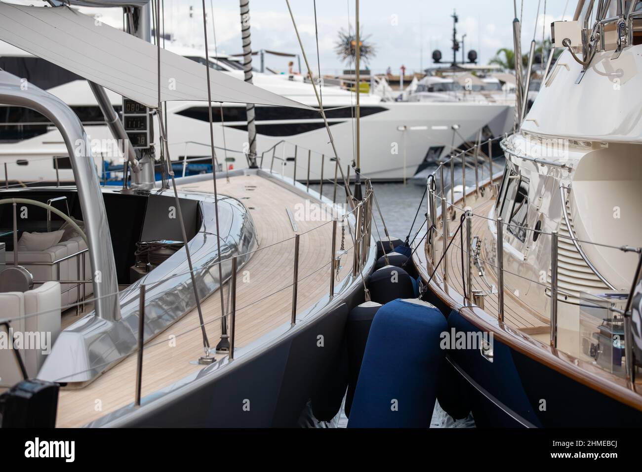 Holzdecks von Segelyachten im klassischen Stil mit Chromgeländer entlang der Kante der Boote in Monaco an sonnigen Tag, hängt eine Menge von Kotflügeln, ein Stockfoto