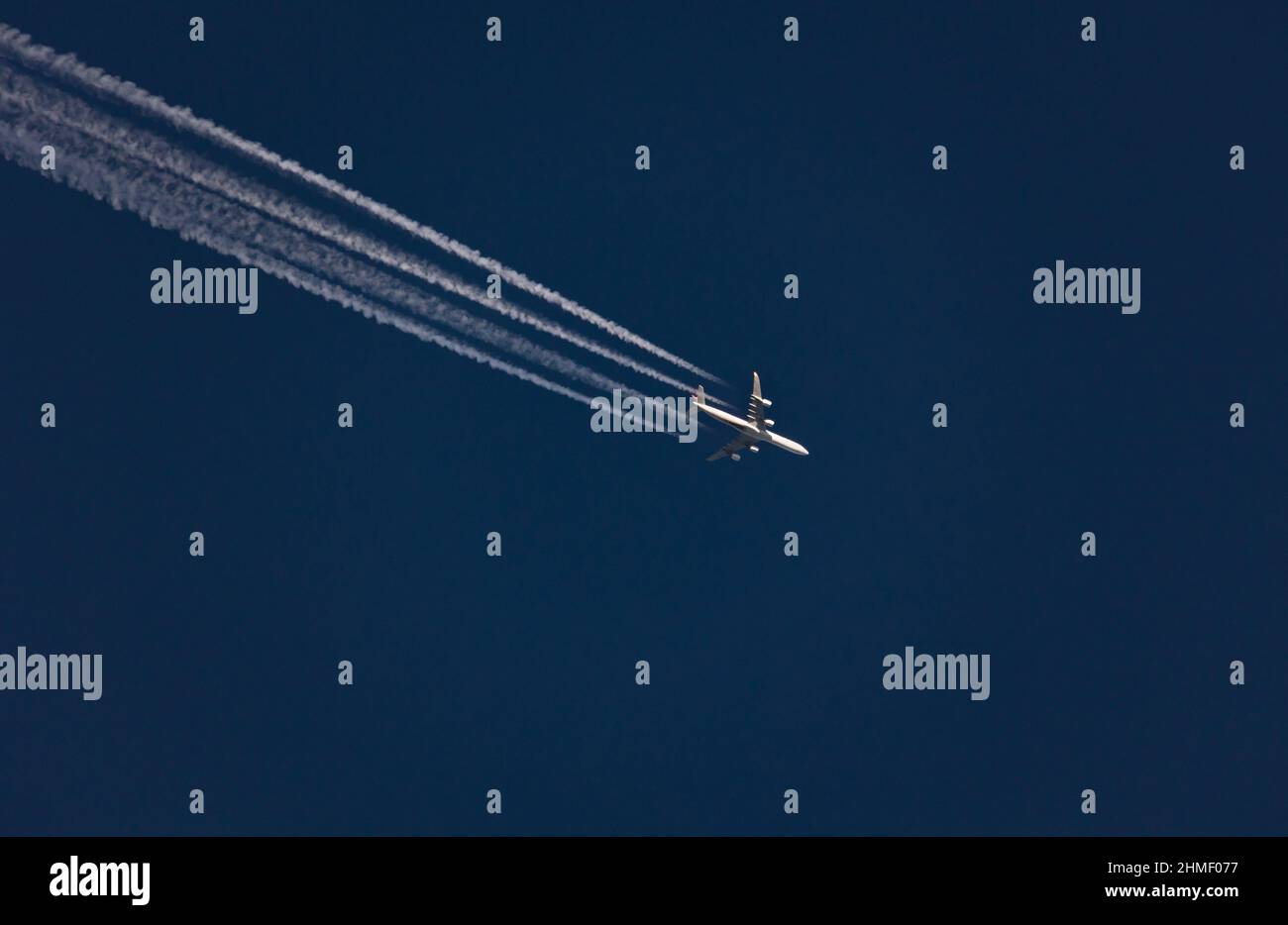 Flugzeug mit vier-Stream-Kondensstreifen gegen blauen Himmel Stockfoto