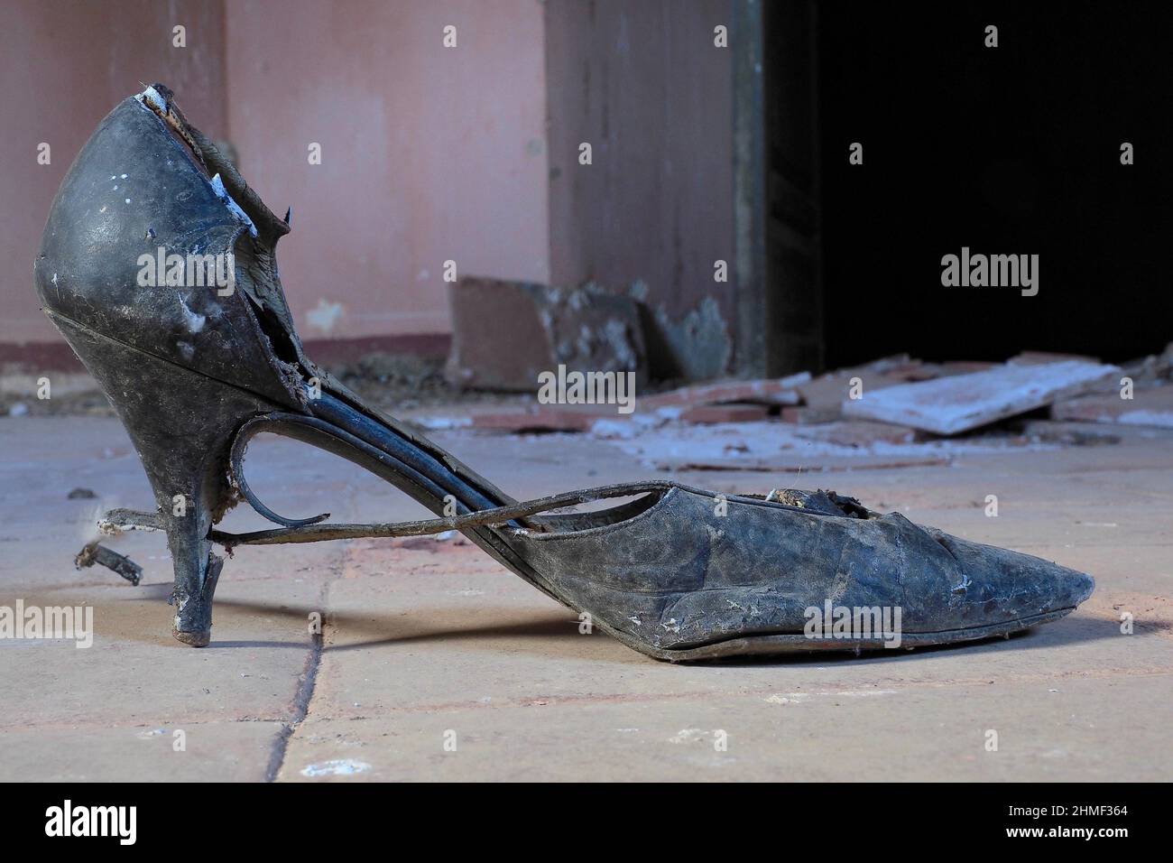 Spitzer Damenschuh mit Gurt, schwarzer Tanzschuh mit Gurt unten, fauler Schuh unten, Schuhwrack, fauler Kicker, abgenutzter Schuh, abgewohnt Stockfoto
