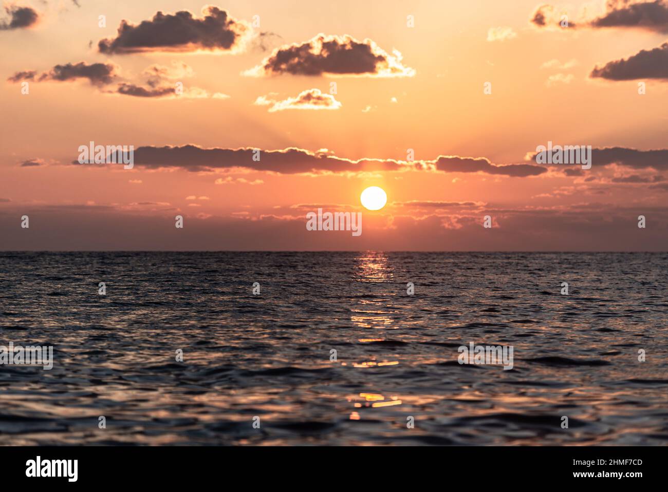 Schöner Sonnenuntergang im Winter in Zypern. Orangefarbene Farben der niedrigen Sonne im Mittelmeer. Stockfoto