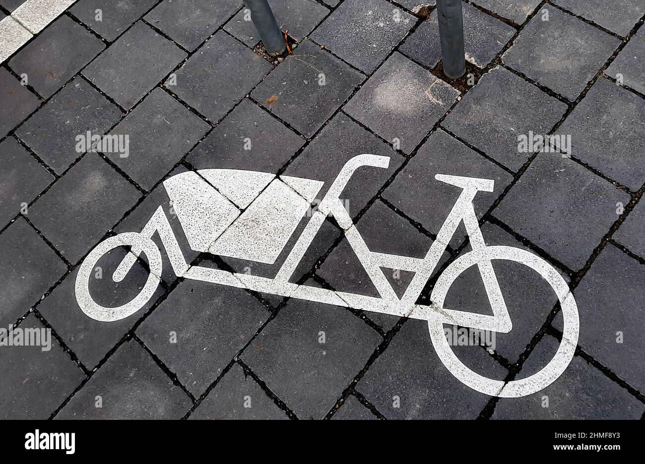 Parkplatz für Lastenräder. Ein auf dem Bürgersteig lackiertes Symbol zeigt ein Lastenrad neben einer Halterung. Hannover, 5. Februar 2022 --- Parkplatz für Lastenräder. Ein auf den Bürgersteig gemaltes Symbol zeigt ein Lastenfahrrad neben einem Befestigungsbügel. Hannover, 5.2.2022 Stockfoto