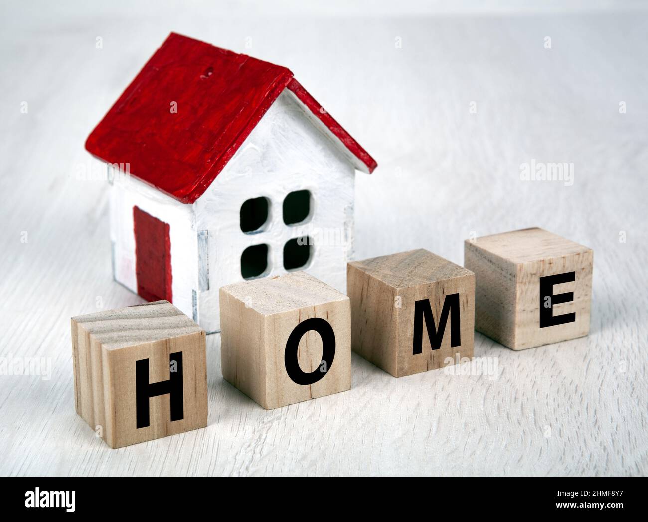 Kleines weißes Holzhaus und Würfel mit der Inschrift Home closeup Stockfoto