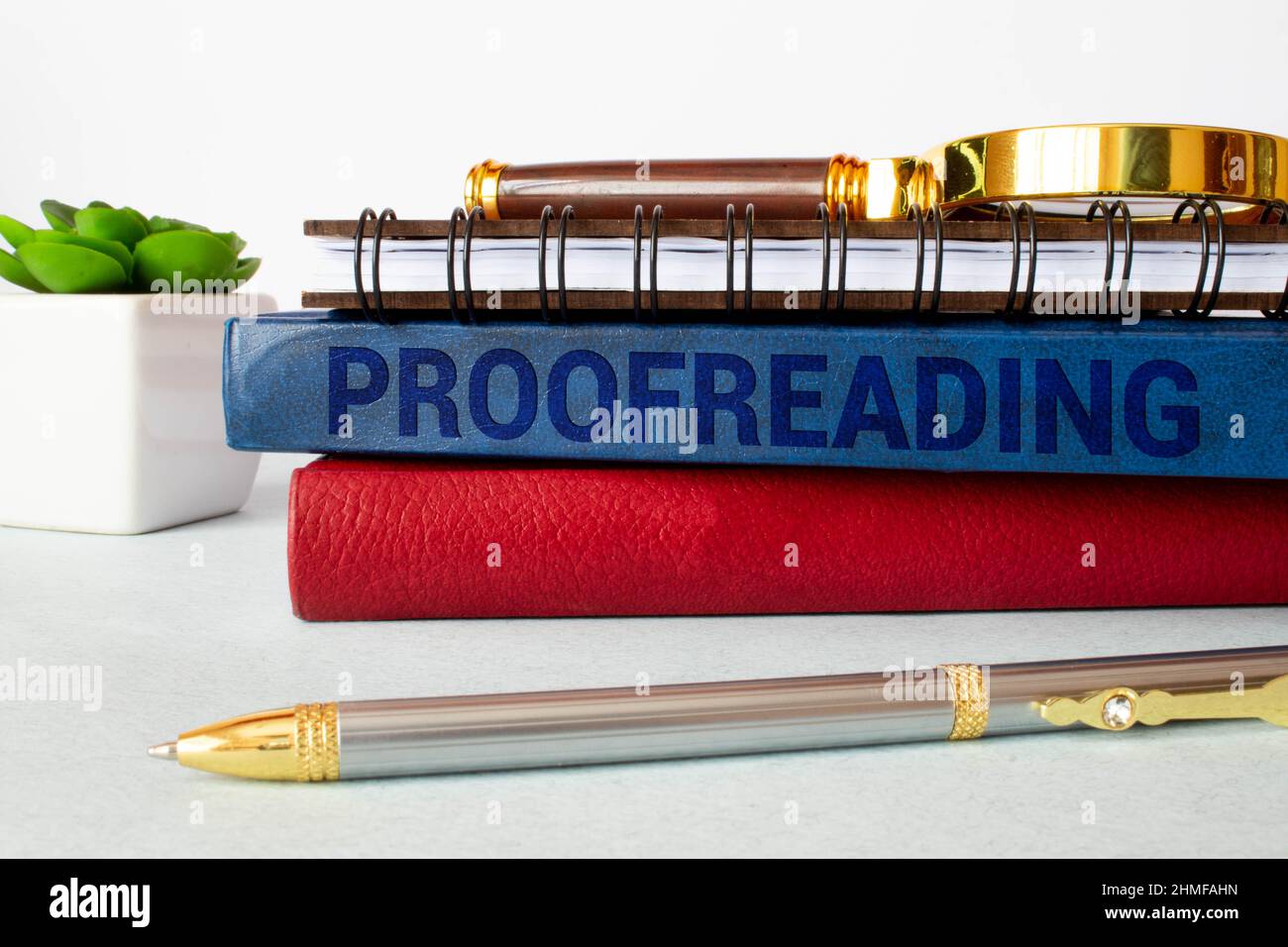 Korrektur der Beschriftung auf einer weißen Notizkarte auf dem Tisch neben einem Stift und einem Rechner. Stockfoto