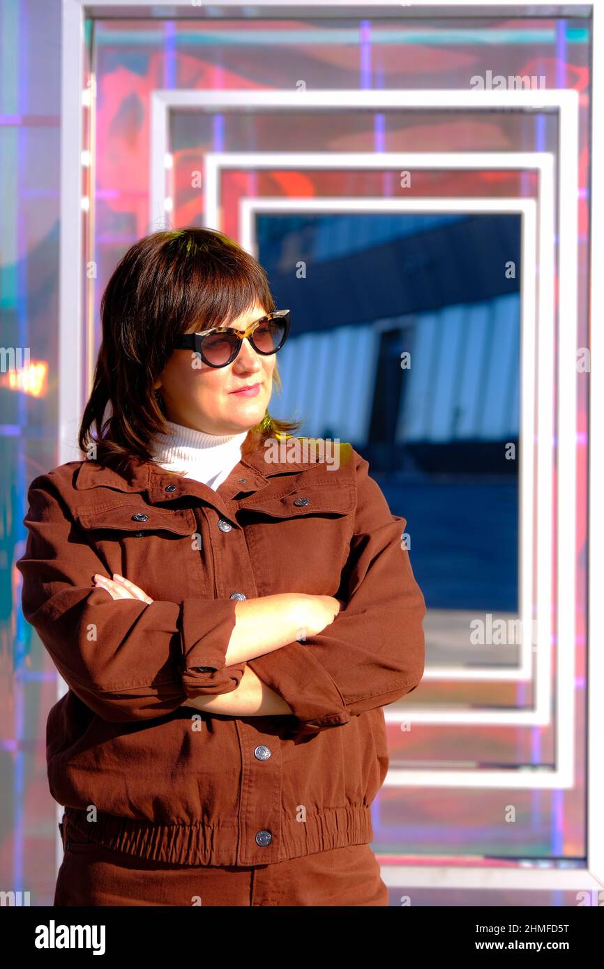 Frau aus der Mitte der dreißiger Jahre, die in einer großen Stadt unterwegs ist. Stockfoto