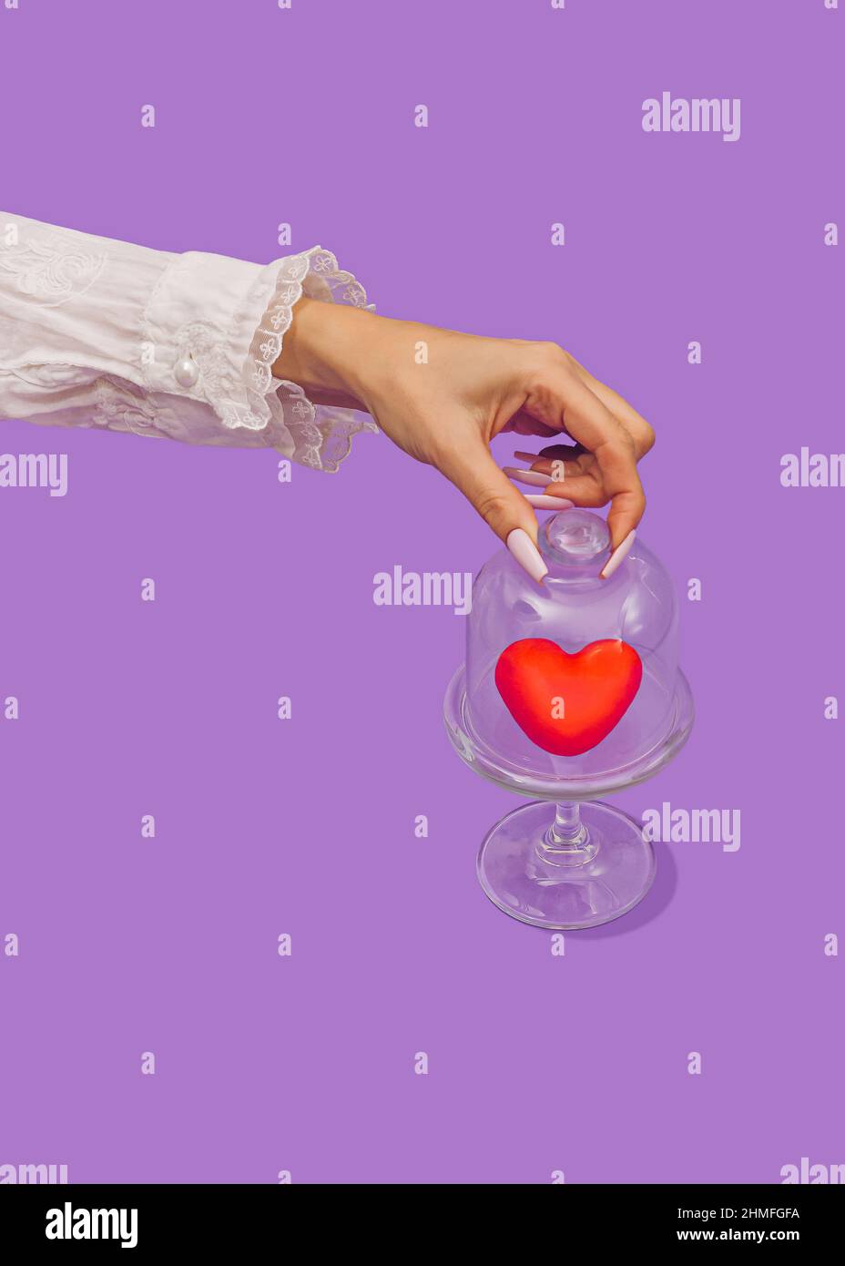 Die Hand der Frau öffnet Bonbons Glas mit dem großen roten Herzen. Liebe und Engagement Konzept. Süße köstliche Liebe Dessert für ein Paar. Valentinstag Stockfoto