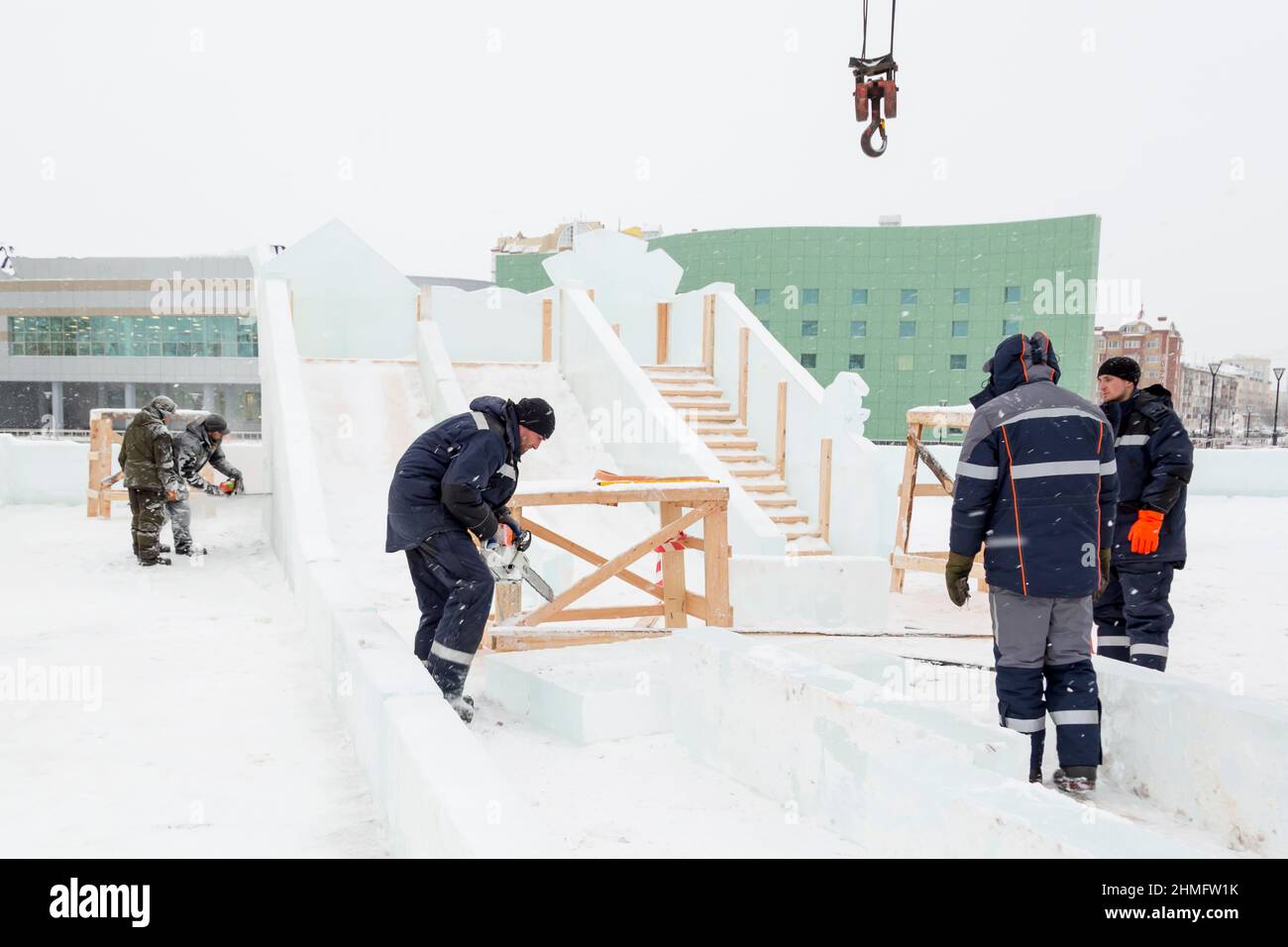 Auf der Baustelle der Eisstadt bauen Installateure eine Eisrutsche Stockfoto