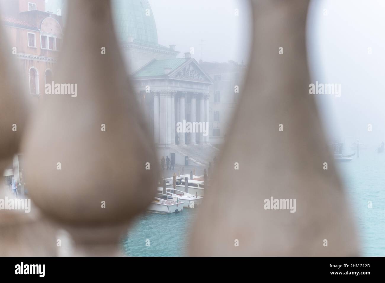 Blick durch den Brückenzaun auf Boote und altes Gebäude Stockfoto