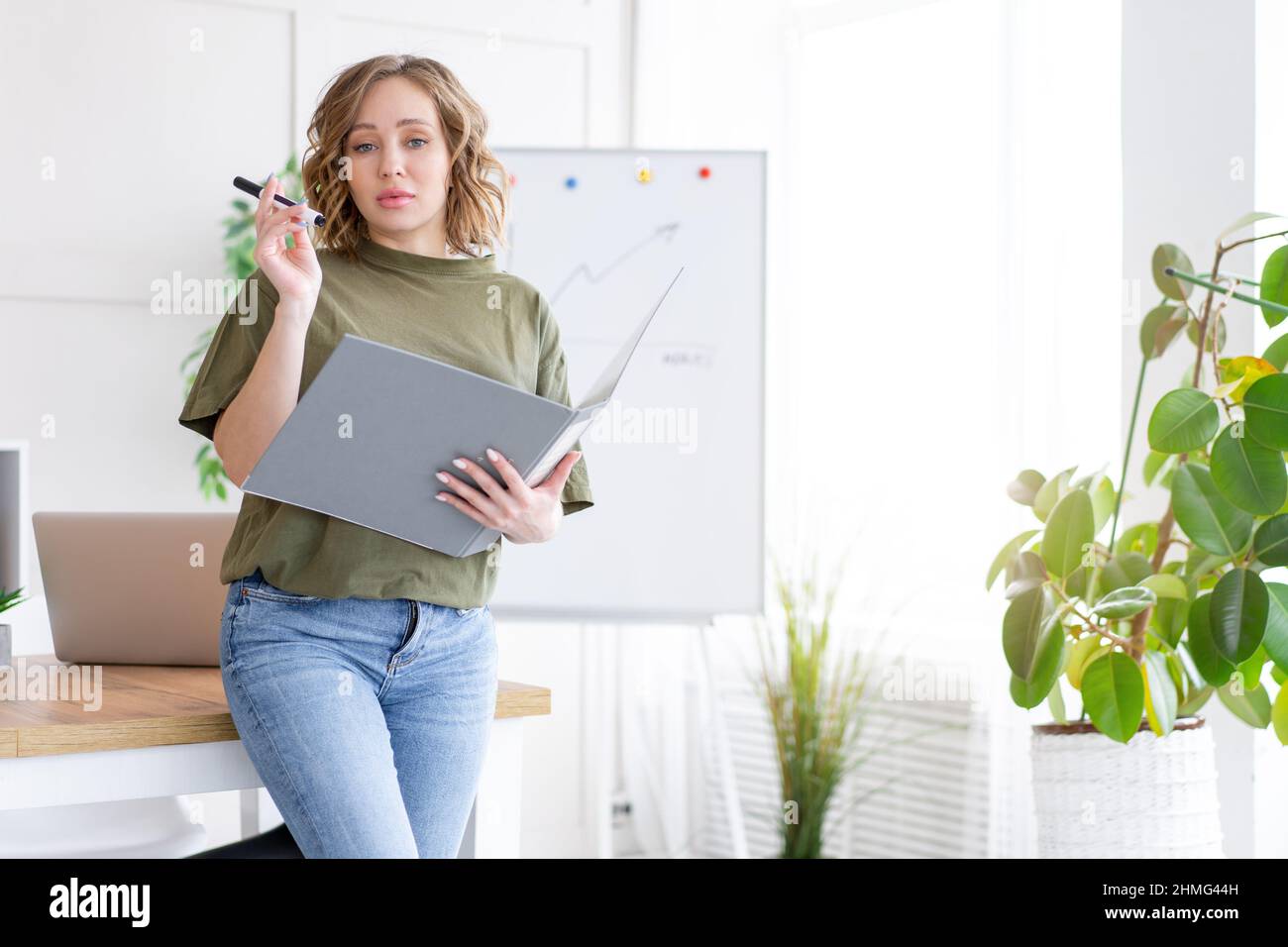 Geschäftsfrau hält Ordner für Papier schreiben Marker denken träumen neben Bürotisch stehen. Business Person femal ypoung Erwachsenen kaukasisch auf Modus Stockfoto
