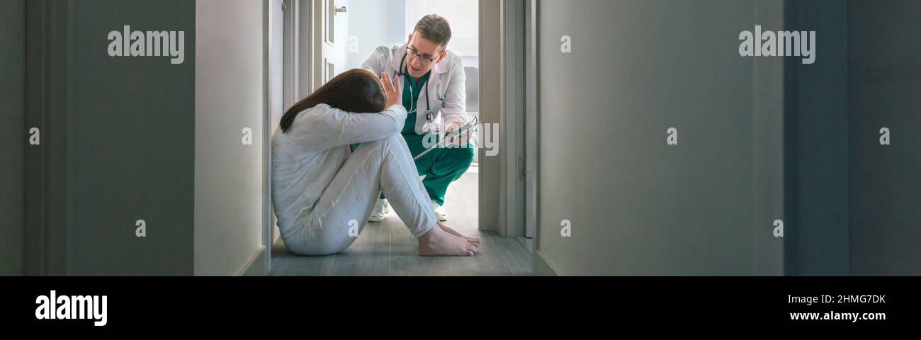 Arzt, der versucht, einer Patientin mit geistiger Störung zu helfen, die die Hilfe im Krankenhaus verweigert Stockfoto