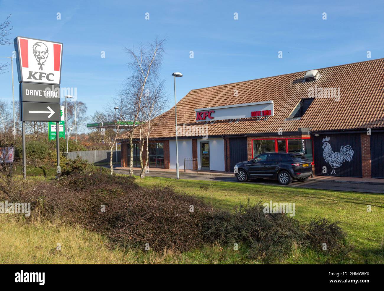 Bannerschild Colonel Sanders wirbt für KFC Kentucky Fried Chicken Drive Thru Outlet, Martlesham, Suffolk, England, Großbritannien Stockfoto