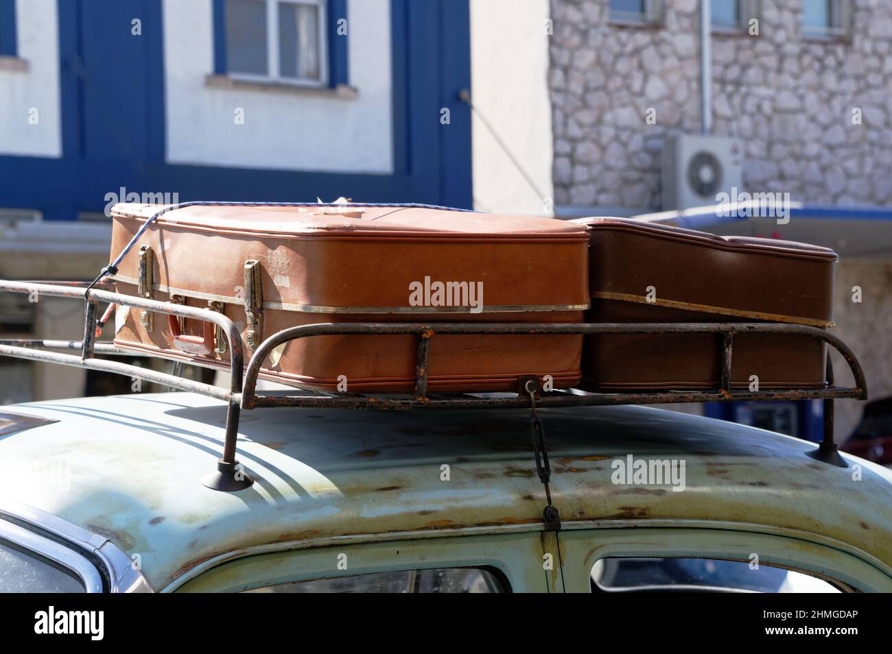 Alte Koffer werden an die Dachgepäckträger eines Oldtimer gebunden Stockfoto