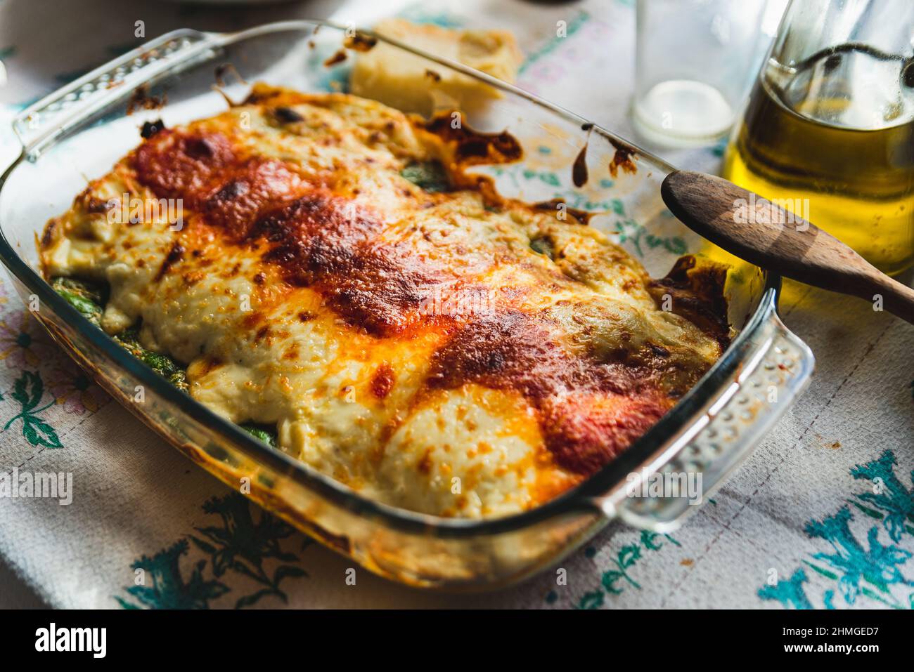 Cannelloni mit Spinat aus nächster Nähe, Tomatensauce, Bachamel und Käse auf Tischtuch. Traditionelle hausgemachte klassische italienische Küche Konzept. Stockfoto