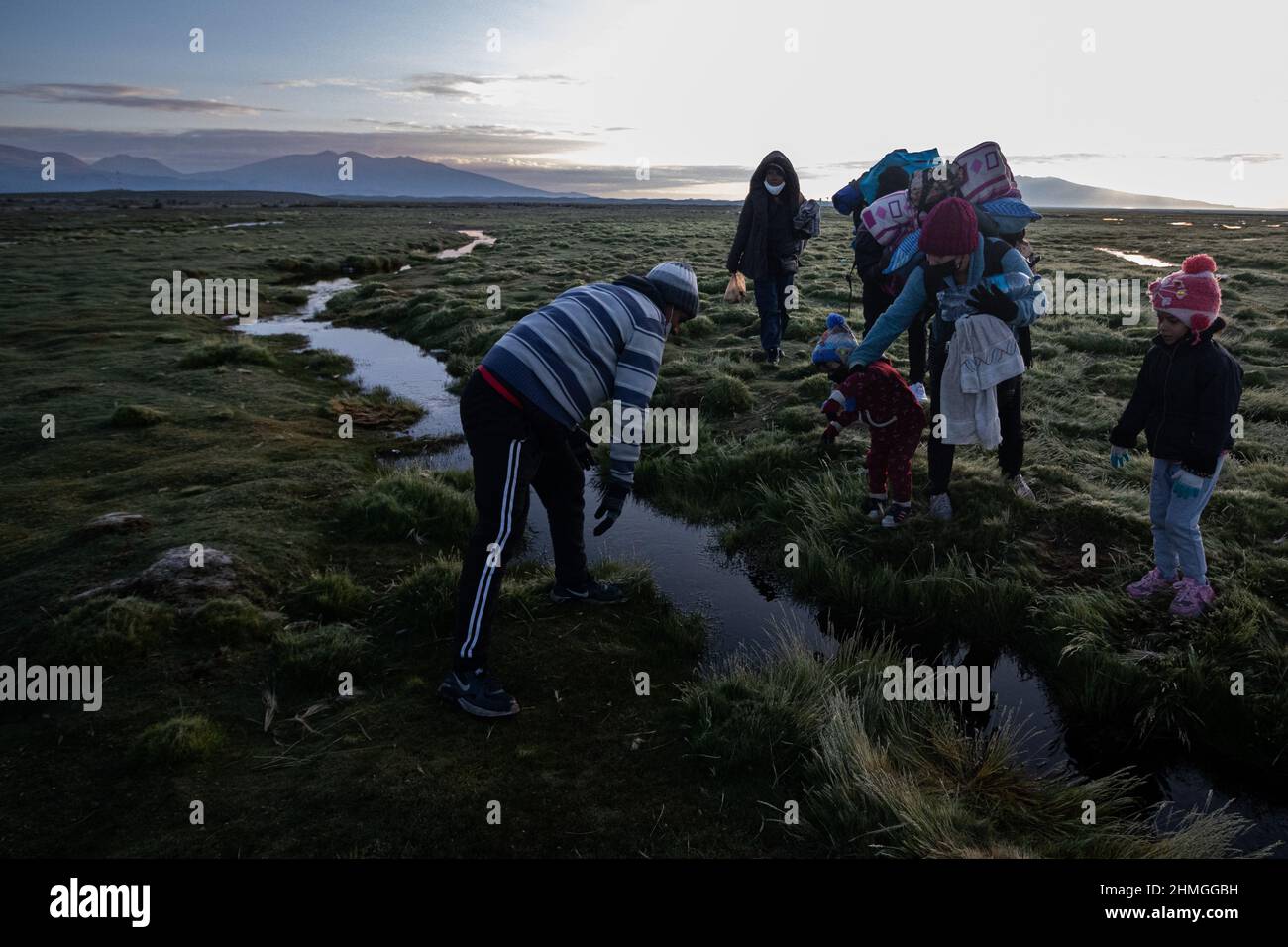 Tägliche Migranten sehen, wie sie auf ungünstigen Straßen nach Chile zwischen der bolivianischen Grenze in Colchane wandern.venezolanische Migranten kommen nach Chile, um aufgrund der Wirtschaftskrise in Venezuela nach Arbeitsmöglichkeiten zu suchen. Nach der Ankunft in Chile versuchen die meisten, in die chilenische Hauptstadt Santiago zu gehen, und dort arbeiten sie in allem, was es braucht, um ihren Familien in Venezuela Geld zu schicken. Die Bevölkerung der Venezolaner in Chile erreicht 500.000 Menschen. Stockfoto