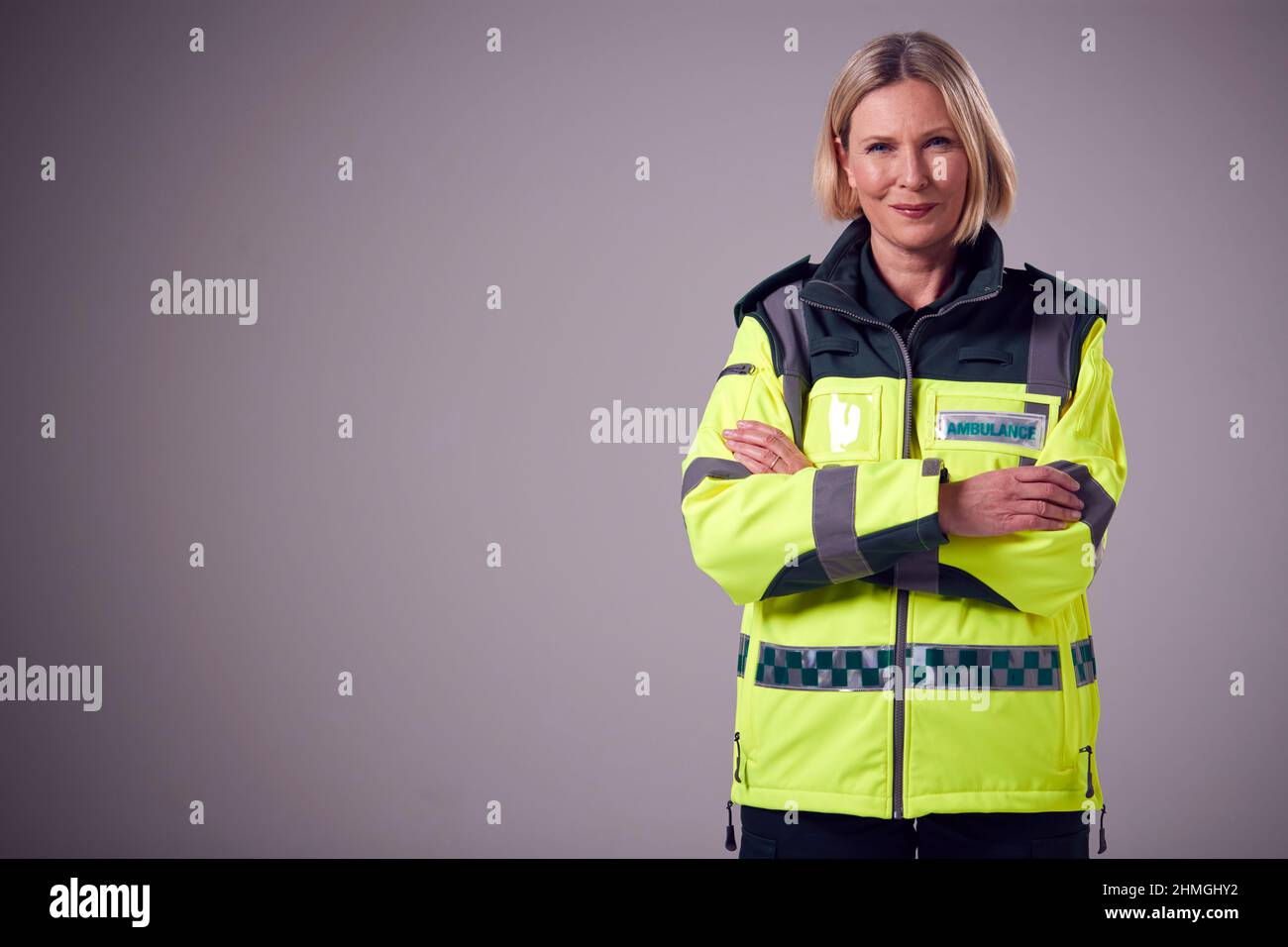 Studio Portrait Of Smiling Reife Frau Sanitäter Gegen Einfachen Hintergrund Stockfoto