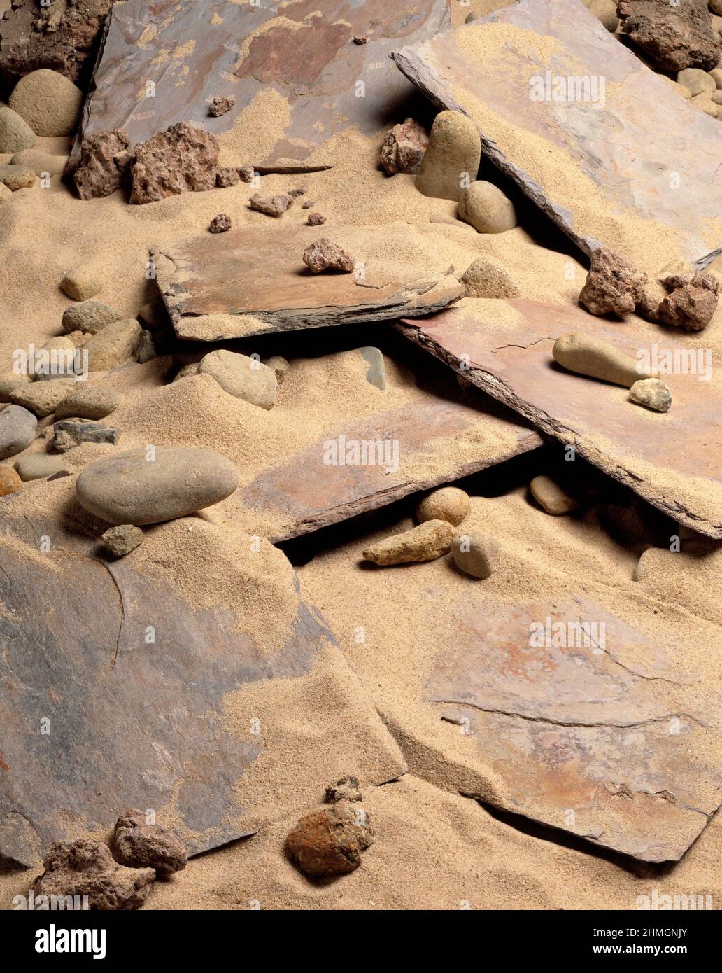 Stillleben. Nahaufnahme von Schieferfliesen und Kieselsteinen an einem Sandstrand. Stockfoto
