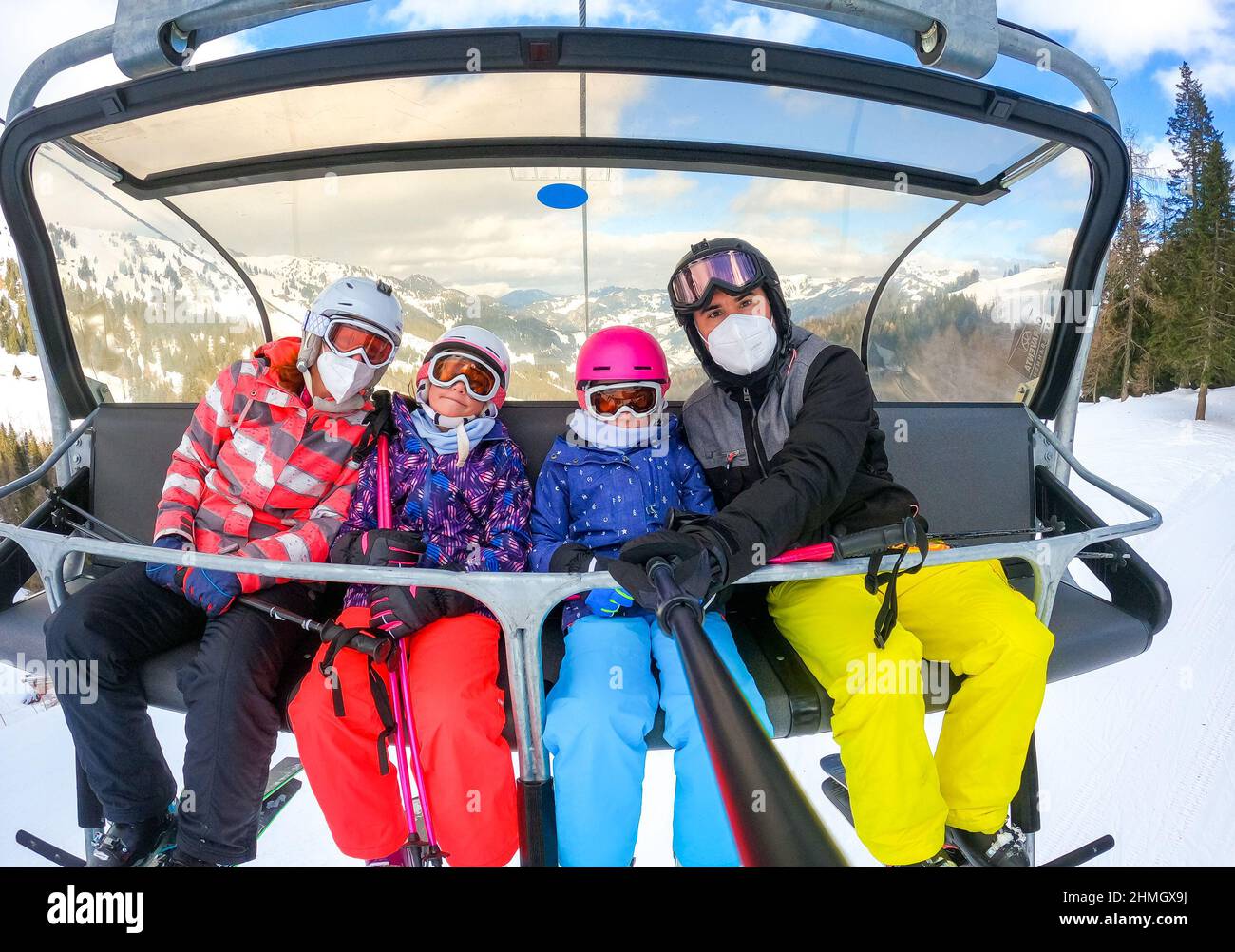 Familien Reiten Skilift Seilbahn auf Winterurlaub Skifahren. Familie auf Winterurlaub Skiausflug unter Selfie auf dem Skilift mit herrlichem Blick auf die Berge o Stockfoto