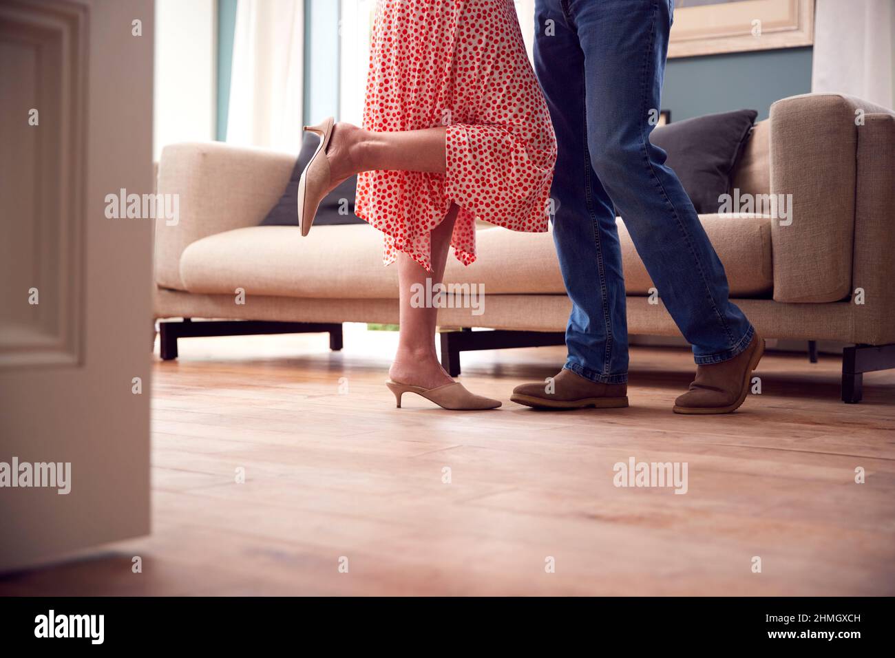 Nahaufnahme Der Beine Als Romantisches Paar Im Ruhestand, Das In Der Lounge At Home Together Tanzt Stockfoto