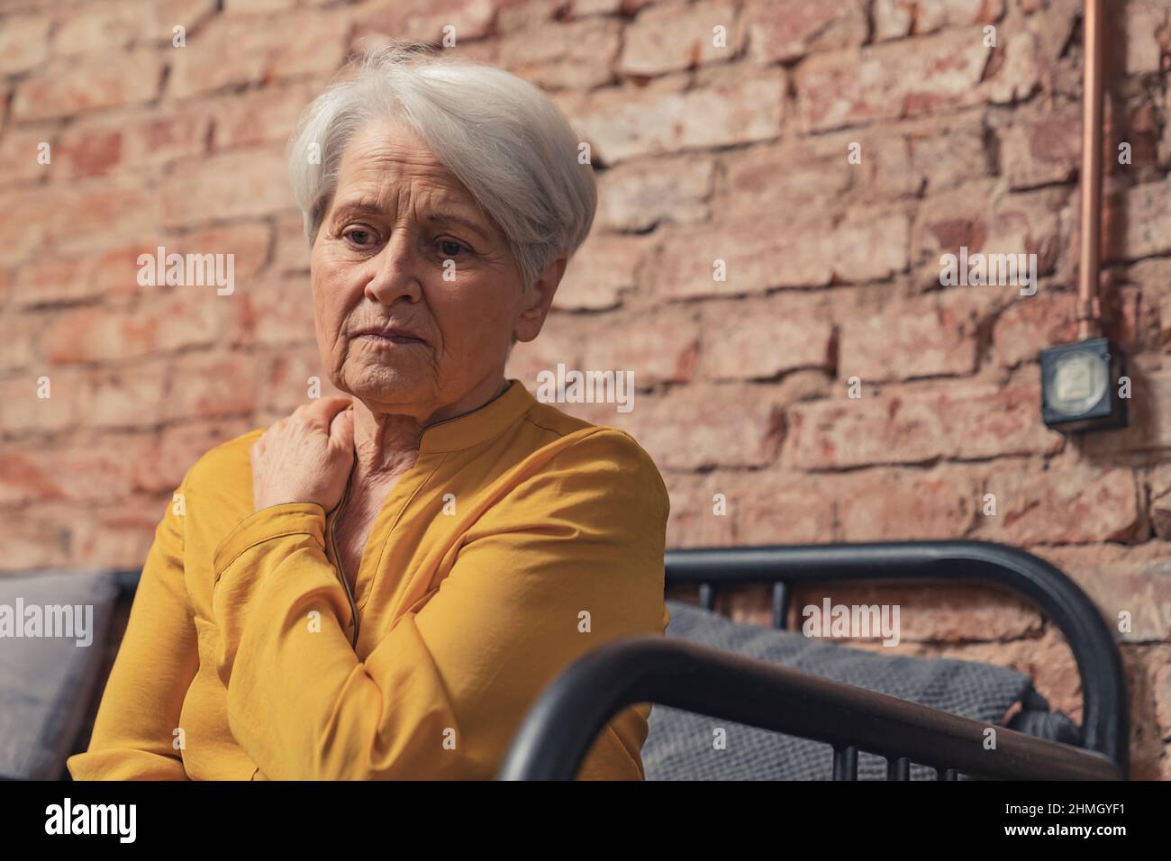 Einsame deprimierte Oma, die allein auf einem Sofa sitzt. Hochwertige Fotos Stockfoto