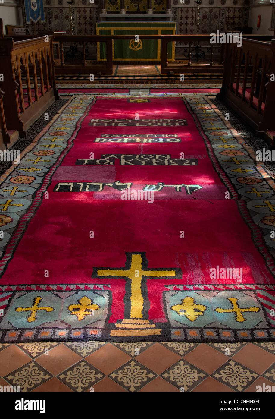 Roter gewebter Teppich mit dem Heiligen an den Herrn in Latein, Griechisch und Hebräisch in der Kirche St. Peter und St. Paul Ringwood UK Stockfoto