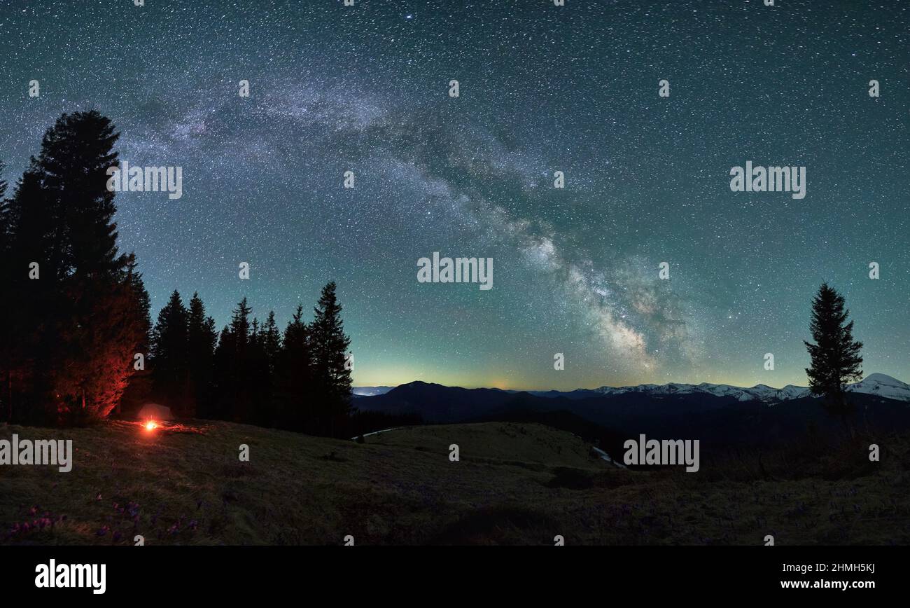 Spektakuläre Naturumgebung mit nächtem Lagerfeuer auf Wandercampingplatz während Wanderlust-Urlauben für das Gefühl der Freiheit, malerischer Sternenhimmel im Tal mit Pinien in den Bergen der Kanne Stockfoto