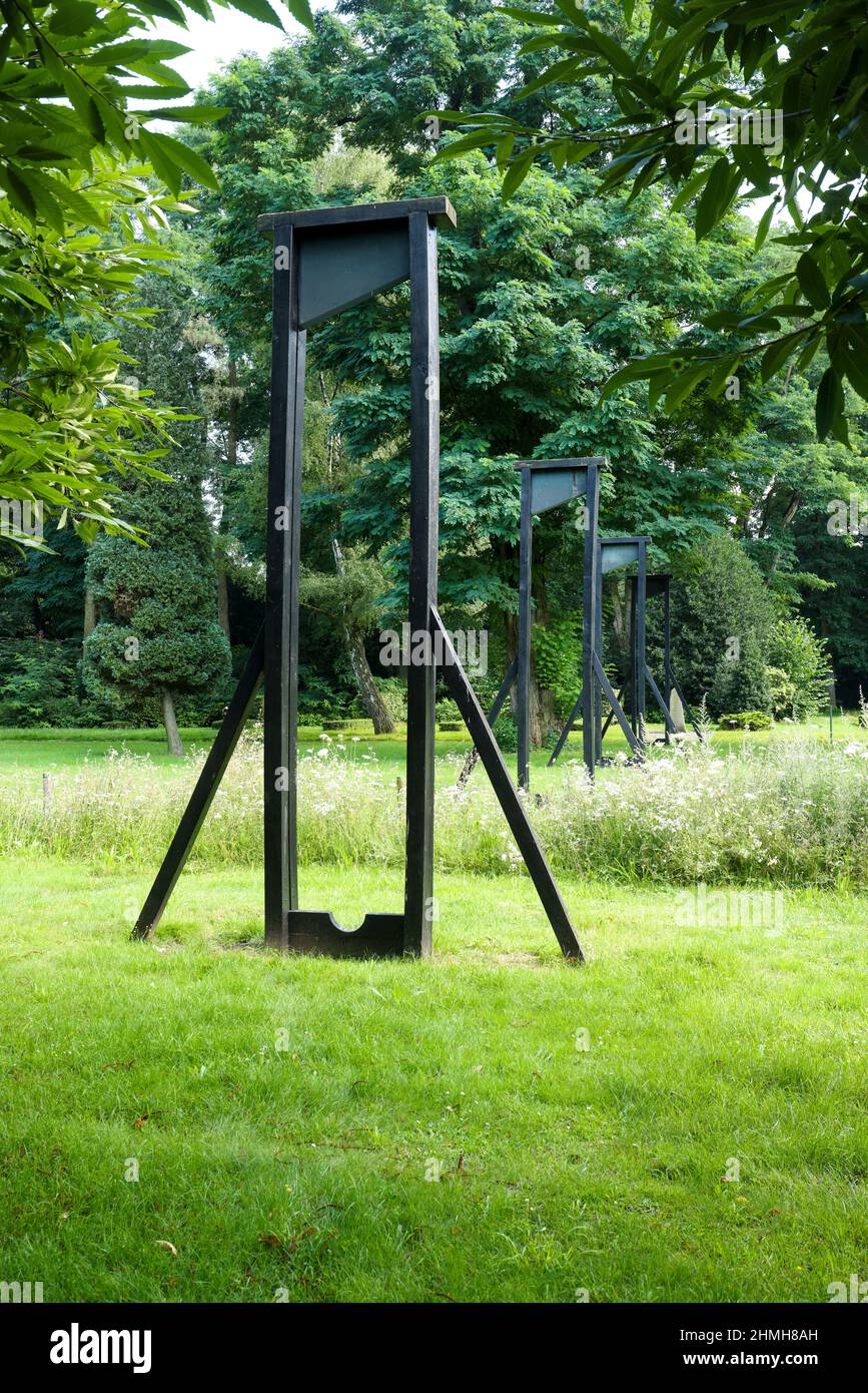 Marl, Nordrhein-Westfalen, Deutschland - Kunstwerk Blick auf den Tempel, vier hölzerne Guillotinen mit bronzenen Guillotinen, von Ian Hamilton Finlay, Kunstwerke im Friedenspark, dem alten brassierten Friedhof. Der alte Friedhof mit dem Skulpturenpark und den Skulpturen im öffentlichen Raum ist Teil der Außenanlagen des Skulpturenmuseums Glaskasten. Stockfoto