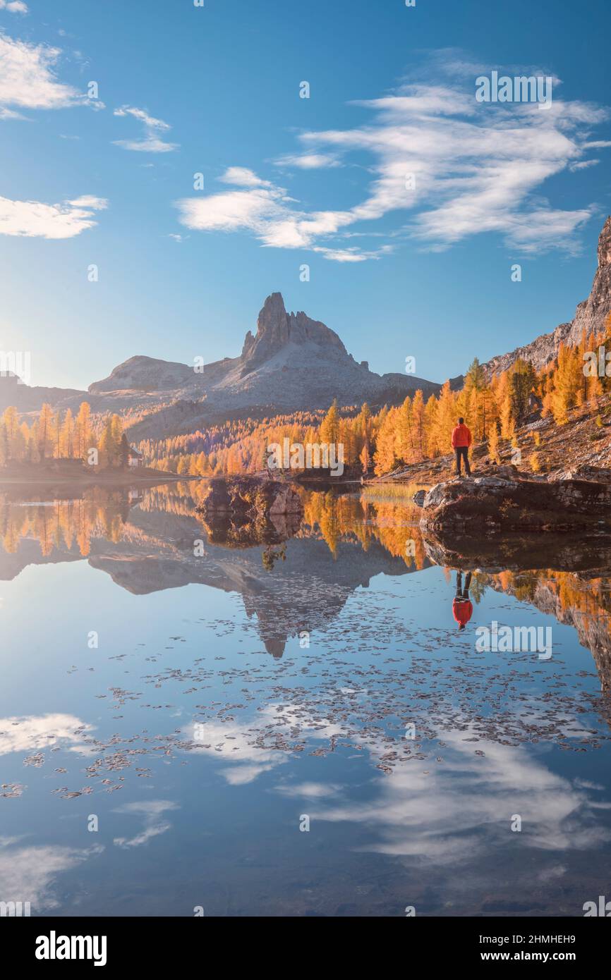 Italien, Venetien, Belluno, Cortina d' Ampezzo, Croda da Lago Hütte, ein Mann (45 bis 50 Jahre), der im Herbst auf einem Felsen am Federa See steht, Stockfoto