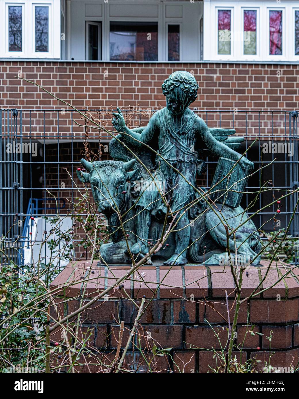 Bronzeskulptur, Luke, einer der vier Evangelisten des Bildhauers Georg Wrba vor dem Wohnhaus in der Wolliner straße, Gesundbrunnen Berlin, Deutschland. Stockfoto