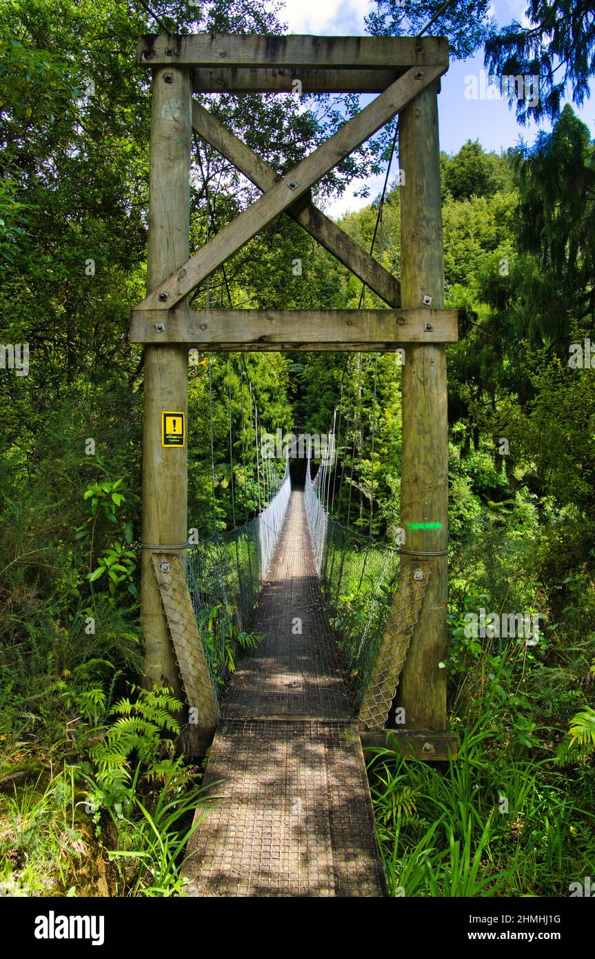 Hölzerne Hängebrücke für Wanderer über den Ohinemuri River in Karangahake, am Fuße der Coromandel Range, Nordinsel, Neuseeland Stockfoto