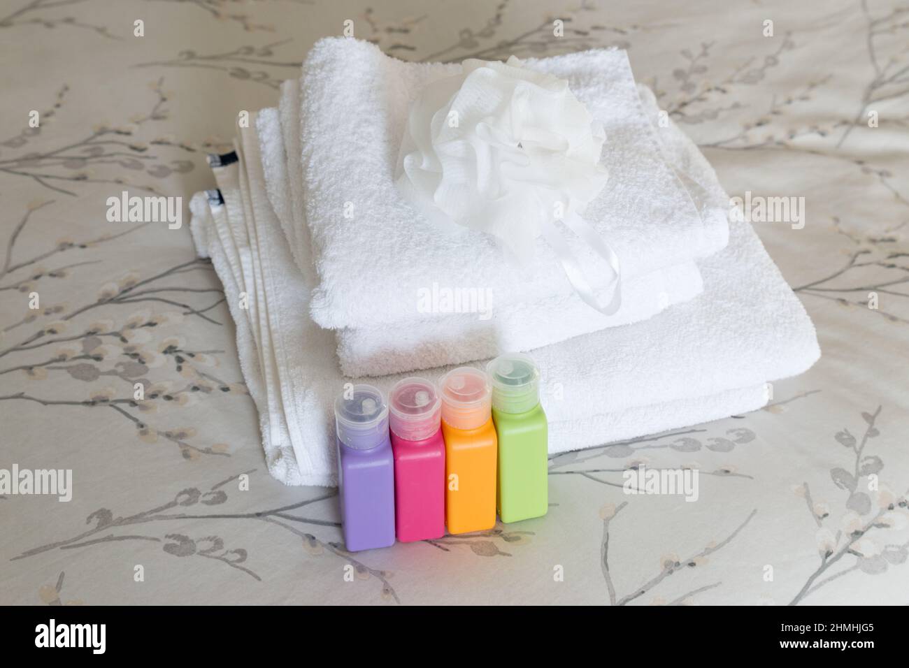 Nahaufnahme von bunten Kunststoff-Beauty-Produkt-Nachfüllflaschen umweltfreundliche Behälter für Shampoo, Duschgel, Lotionen, weißes Handtuch Stockfoto