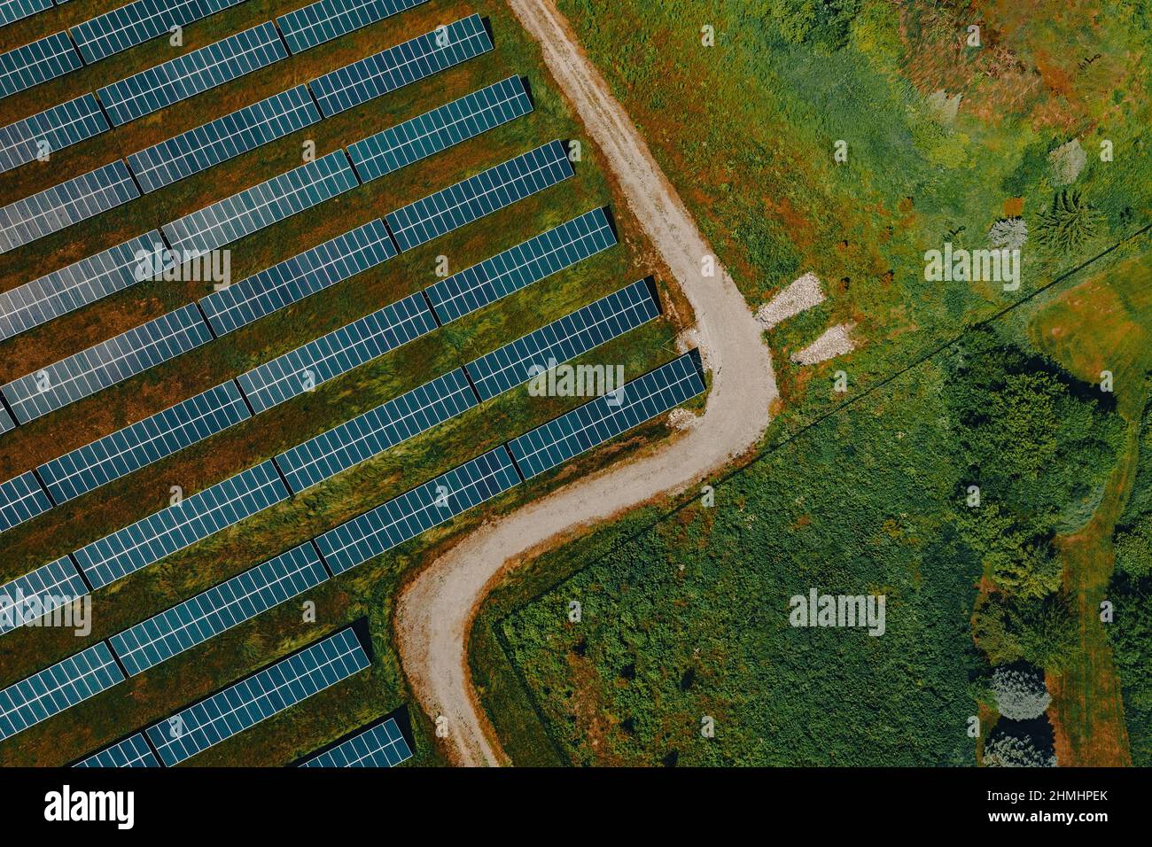 Blick aus der Vogelperspektive auf Reihen von Solarmodulen mit einer Zufahrtsstraße zum Turrill Solar Plant, das Haushalte in Lapeer, Michigan, USA, mit erneuerbarer Energie versorgt Stockfoto