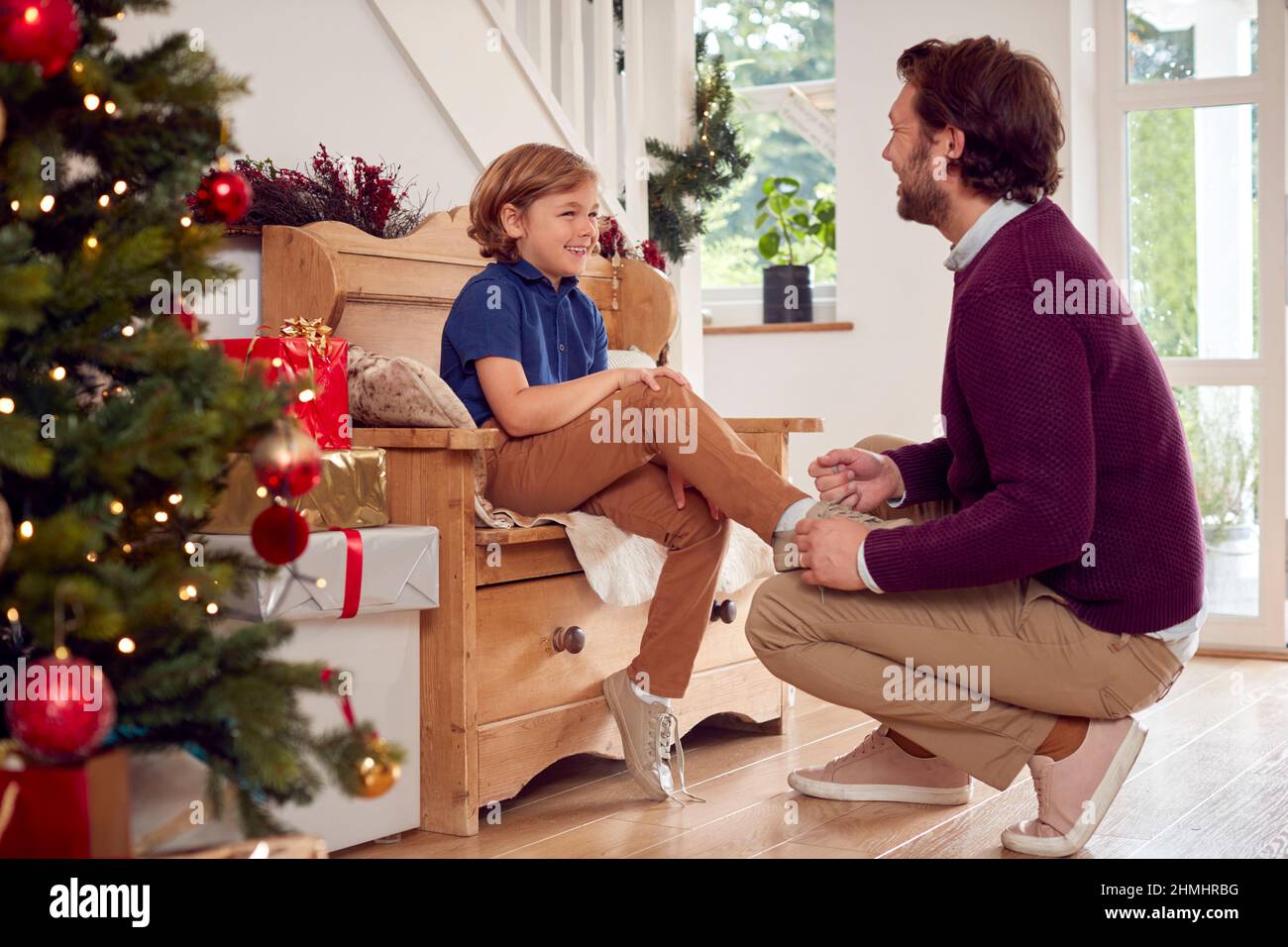 Vater Hilft Sohn Zu Binden Schnürsenkel Im Haus Zu Weihnachten Dekoriert Stockfoto