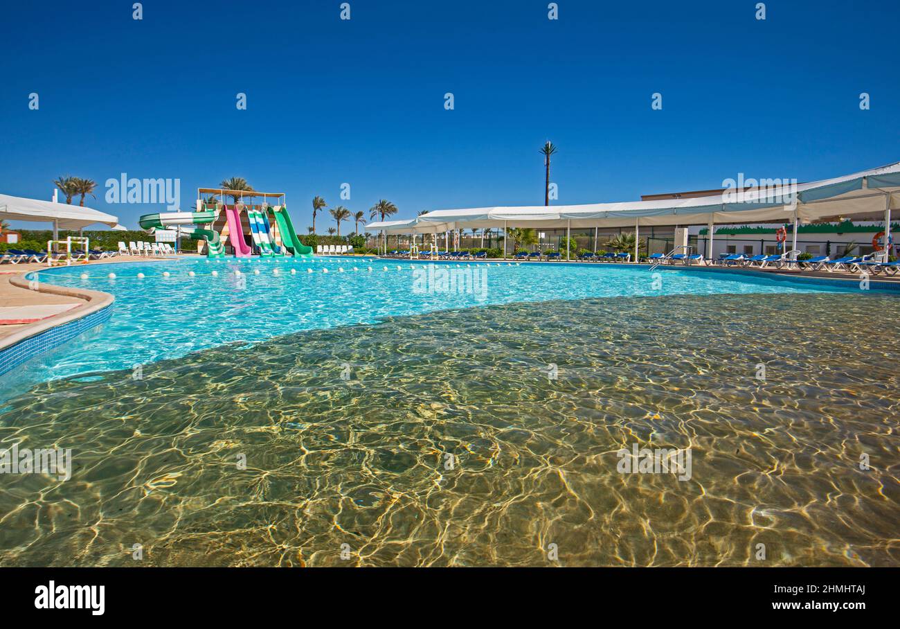 Großer Swimmingpool mit Wasserrutschen im Wasserpark in einem luxuriösen tropischen Hotelresort Stockfoto