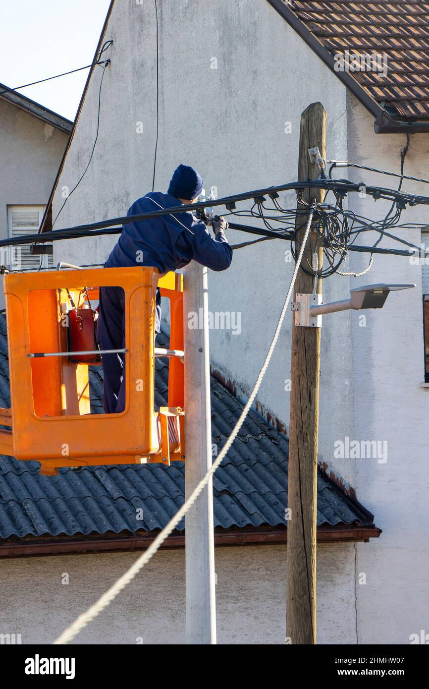 Elektriker Arbeiter auf einem Mast, Reparatur von Stromleitungen Stockfoto