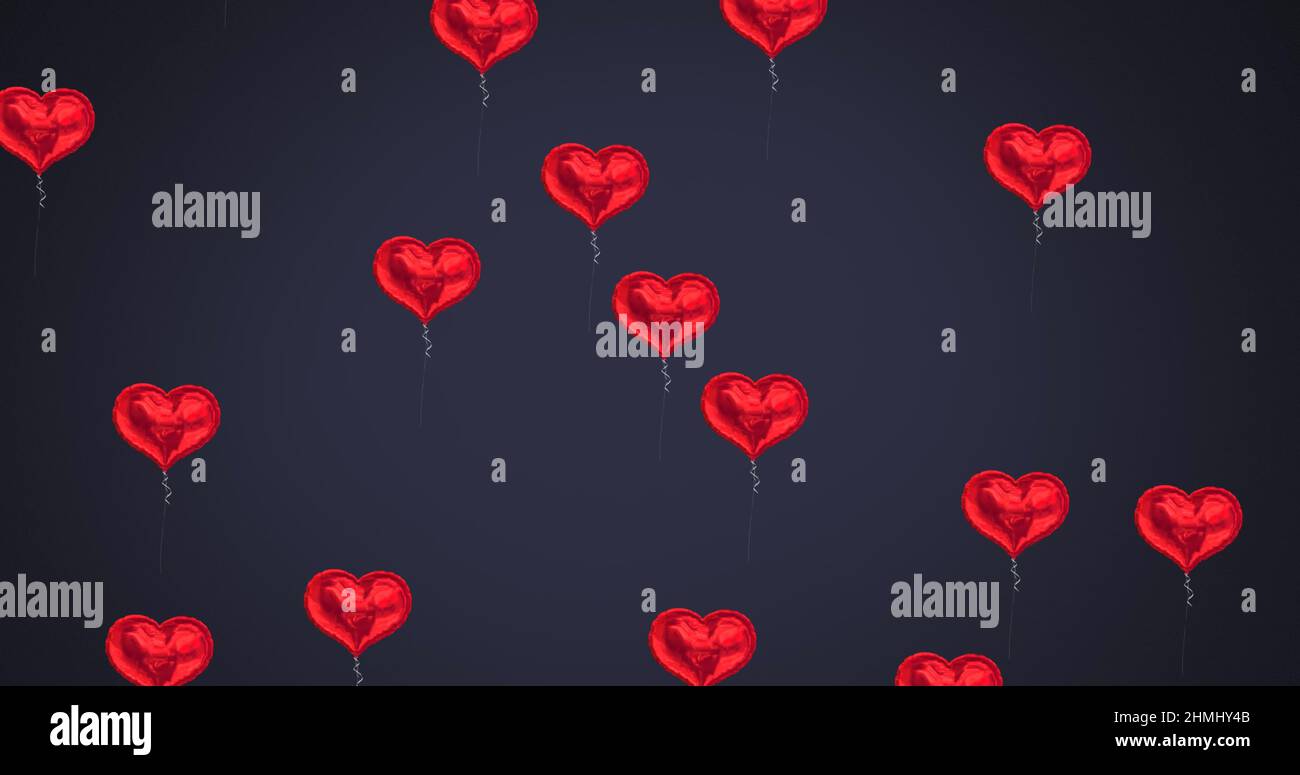 Mehrere herzförmige Ballons schweben vor schwarzem Hintergrund Stockfoto