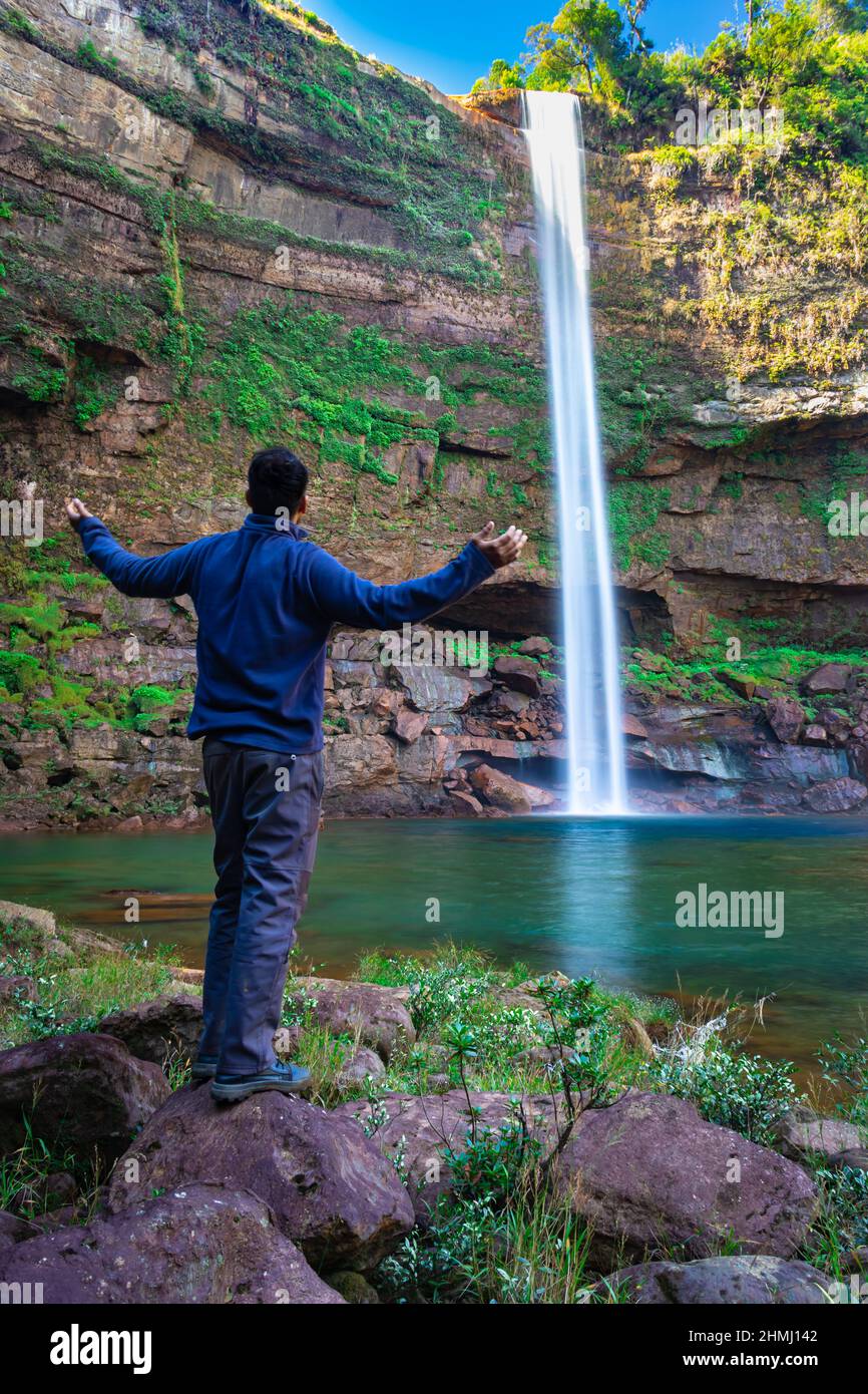 Junger Mann am Wasserfall fallende Ströme von der Bergspitze mit Reflexion aus verschiedenen Perspektiven Bild auf phe phe Fall meghalaya indien aufgenommen. Es ist Stockfoto