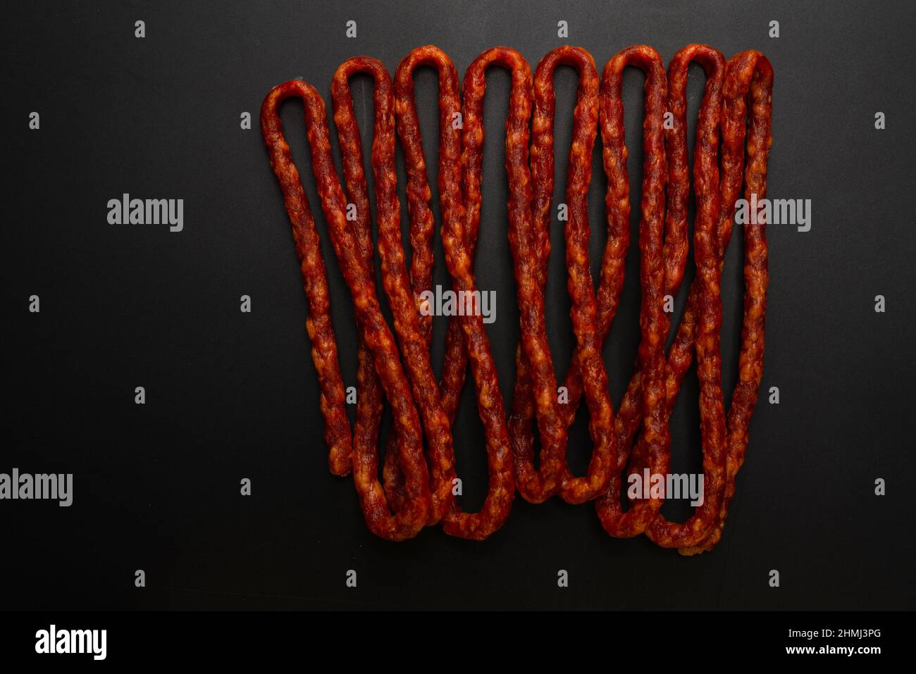 Cabanossi, trockene Wurst isoliert auf schwarzem Hintergrund. Stockfoto