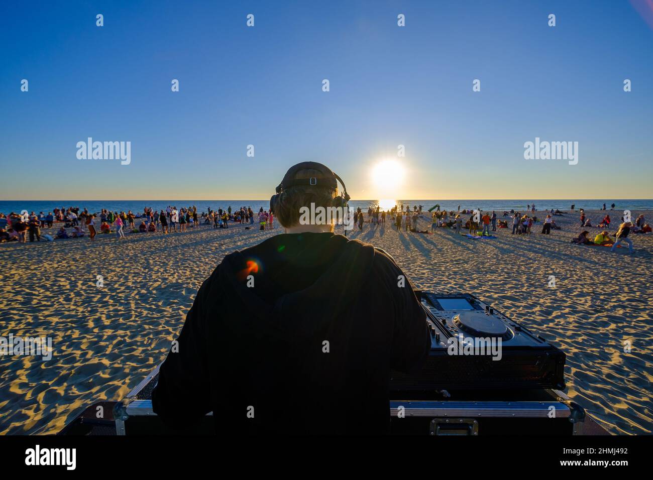 DJ spielt am Strand während des Sonnenuntergangs Musik Stockfoto