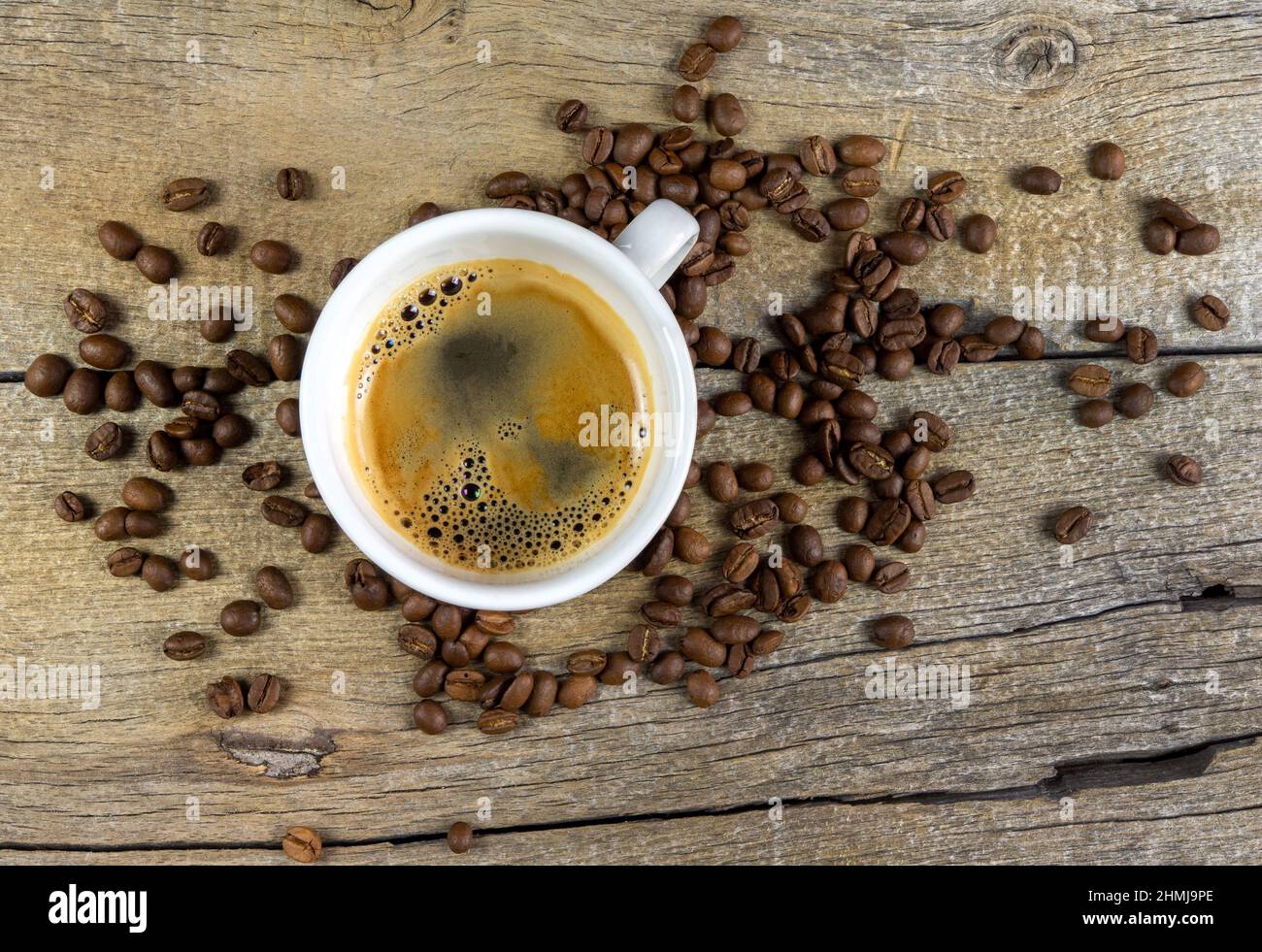 Eine Tasse Kaffee und Kaffeebohnen auf Holzbrett Stockfoto