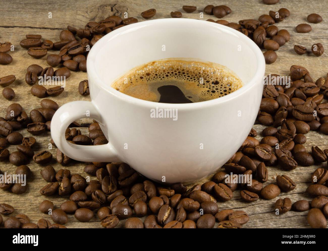 Eine Tasse Kaffee und Kaffeebohnen auf Holzbrett Stockfoto