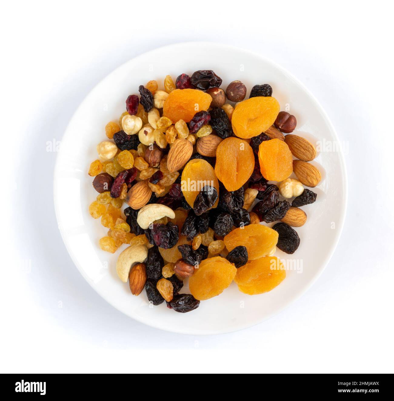 Getrocknete Früchte und Nüsse in Teller auf weißem Hintergrund Stockfoto