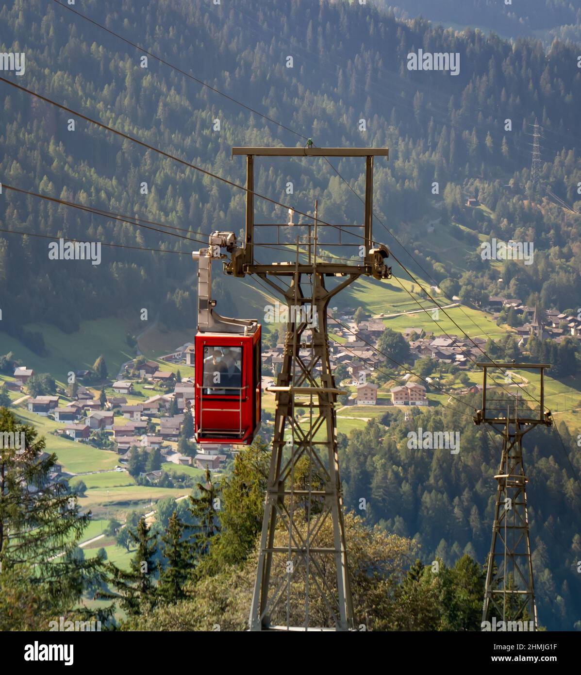Eine Gondelbahn, die den Hügel hinauf in Richtung der Schweizer Stadt Bellwald fährt Stockfoto