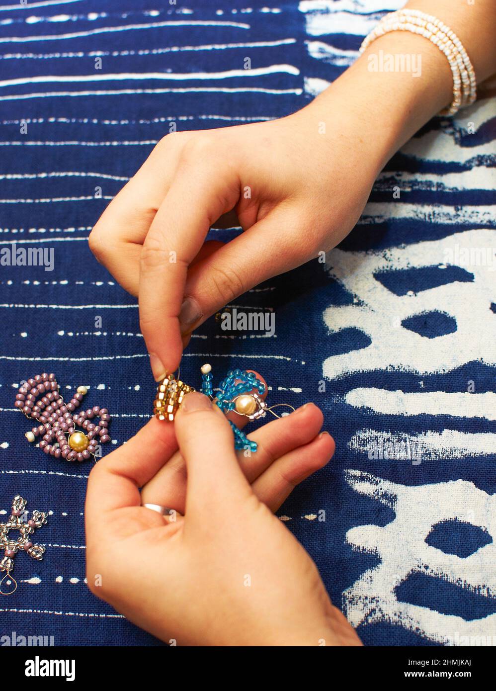 Detail von youn Frau Hände machen eine Perle Engel Dekoration. Workshop-Tutorial für Perlen Stockfoto