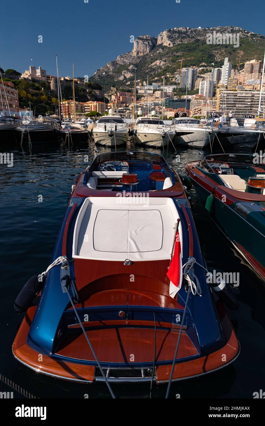 Viele Motorboote in Reihen sind im Hafen von Monaco an sonnigen Tag, Monte Carlo, Berg ist auf dem Hintergrund, bunten Innenraum des Bootes, sind in Anker Stockfoto