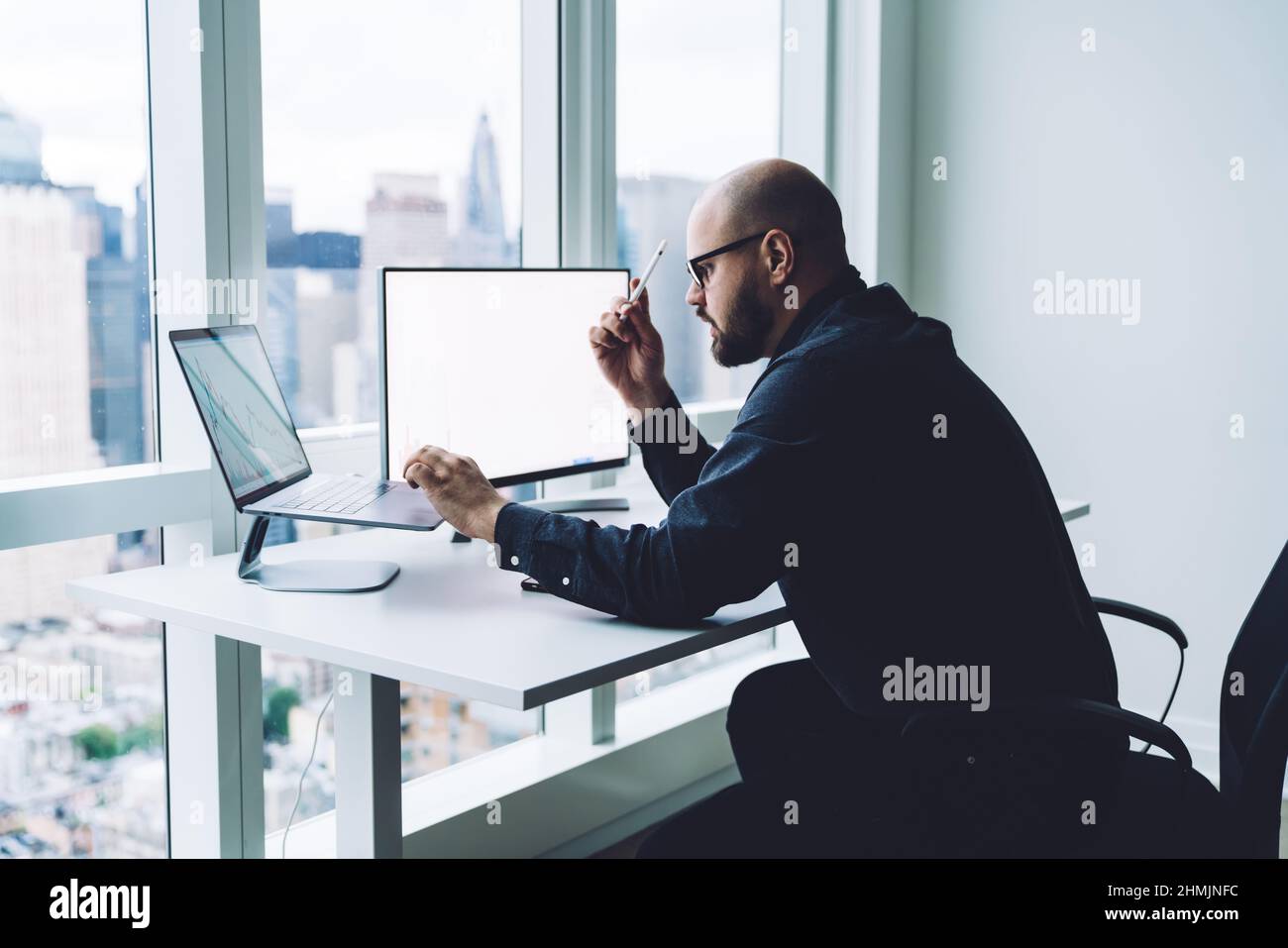 Seriöse Trader sehen sich bei der Arbeit auf dem Laptop-Bildschirm ein Diagramm an Stockfoto