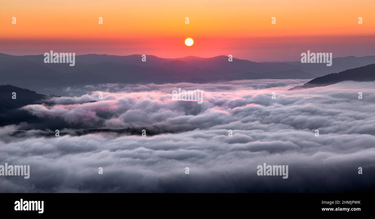 Panorama mit atemberaubendem Sonnenaufgang. Landschaft mit hohen Bergen. Felder und Wiesen sind mit Morgennebel und Tau bedeckt. Touristisches Resort Karpaten Nati Stockfoto